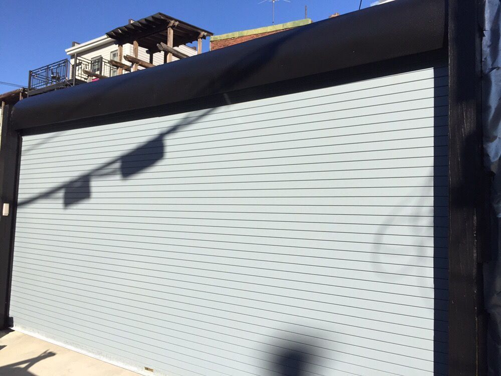 A white garage door with a black frame and a shadow on it.